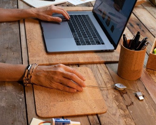 A woman using the Cork Computer Mouse Pad